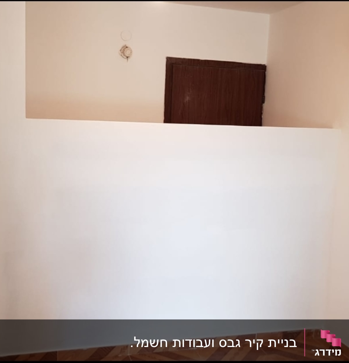 אדם צובע קיר בגבס עם רולר צבע לבן